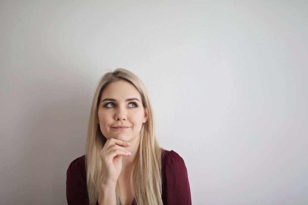 Portrait of a pensive woman with a thoughtful expression against a white background.